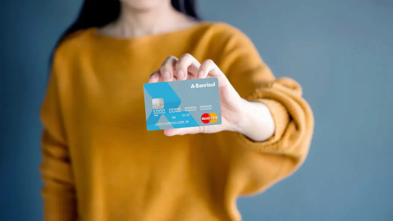 mulher segurando cartão de crédito Banrisul
