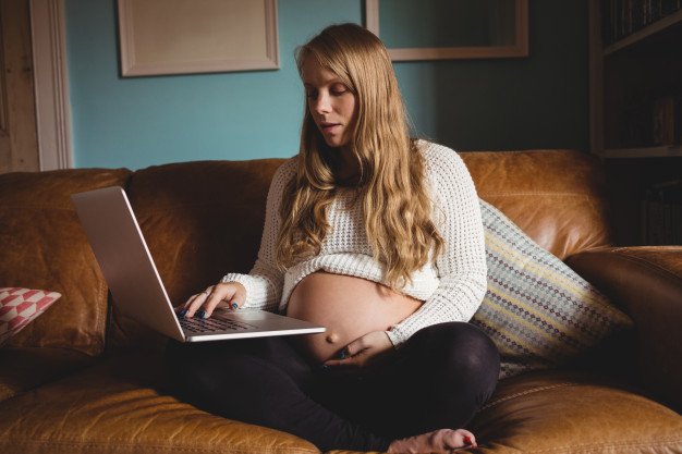 mulher grávida trabalhando em home office