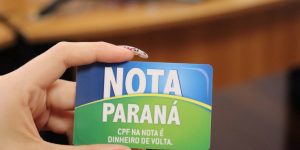 O Nota Paraná é um programa em que o consumidor pode conseguir dinheiro de volta quando pede CPF na nota fiscal no momento de pagar por uma compra, mas existe um valor mínimo para fazer esse resgate. A seguir, você descobre quanto é preciso acumular de saldo no Nota Paraná para resgatar o dinheiro, e confere mais detalhes sobre o programa. Qual o valor mínimo para resgate no Nota Paraná? Os consumidores que participam do Nota Paraná devem acumular um saldo mínimo de R$ 25 para resgatar o valor por meio de depósito em conta bancária. Aproveite para conferir também Nota Curitibana: Como participar? Quais são os benefícios? Este também é o valor mínimo para alterar a conta cadastrada no programa. Para fazer esta mudança, basta digitar o número da nova conta quando o saldo estiver acima de R$ 25 e o consumidor for resgatar o dinheiro. De acordo com as regras de resgate de crédito, o dinheiro disponível pode ser depositado em contas de qualquer banco do Sistema Financeiro Nacional. Porém, a conta não pode ser de Bolsa Família/Auxílio Brasil, Cartão Cidadão, Conta Fácil, Conta Benefício e Conta Salário. Além disso, a conta deve pertencer ao próprio consumidor, pois não é possível depositar o saldo para outra pessoa. No caso dos inscritos no Nota Paraná como pessoa física, não é possível resgatar o dinheiro do programa por meio de depósito em conta de pessoa jurídica. Como resgatar o dinheiro do Nota Paraná? Para resgatar o saldo por meio de depósito em conta bancária, basta acessar sua conta no site do Nota Paraná e clicar em 